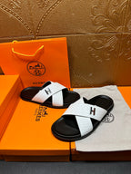 White textured H logo slide sandals on black footbeds, shown with both shoes