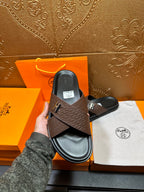 Brown textured leather slide sandals, black footbed, H buckle; held upright