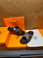 Brown textured leather slide sandals with black footbed and H buckle, side view