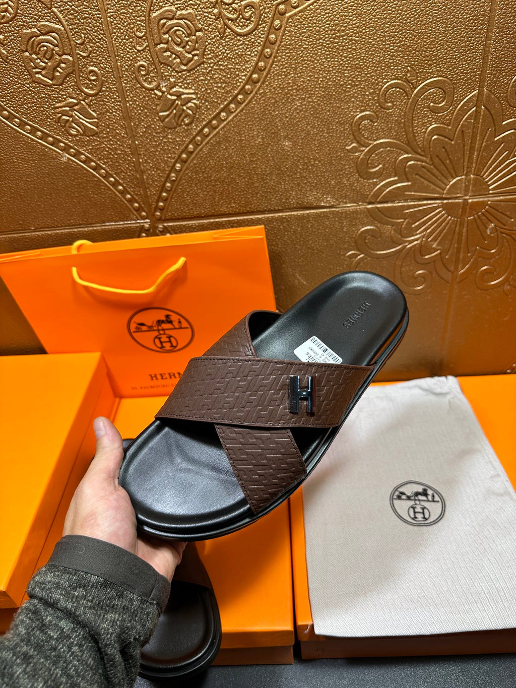 Brown leather slide sandals with black sole and H logo strap, shown from above
