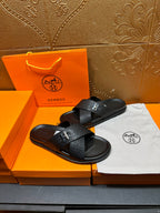 Black textured H-buckle slide sandals with flat sole