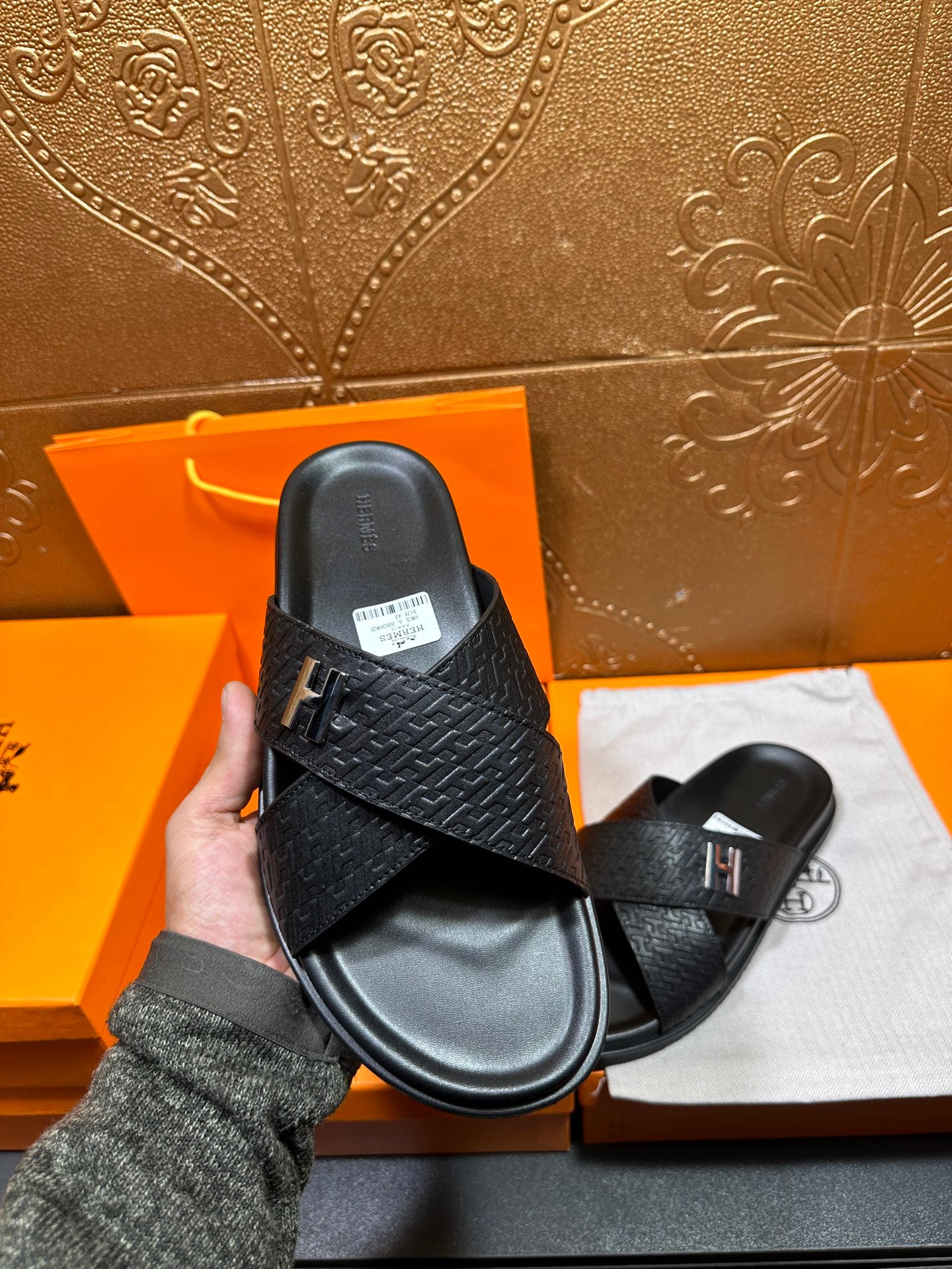 Black textured slide sandal with H buckle, showing top and footbed