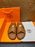 Hermes slide sandals with tan textured cross straps and H buckle, open toe