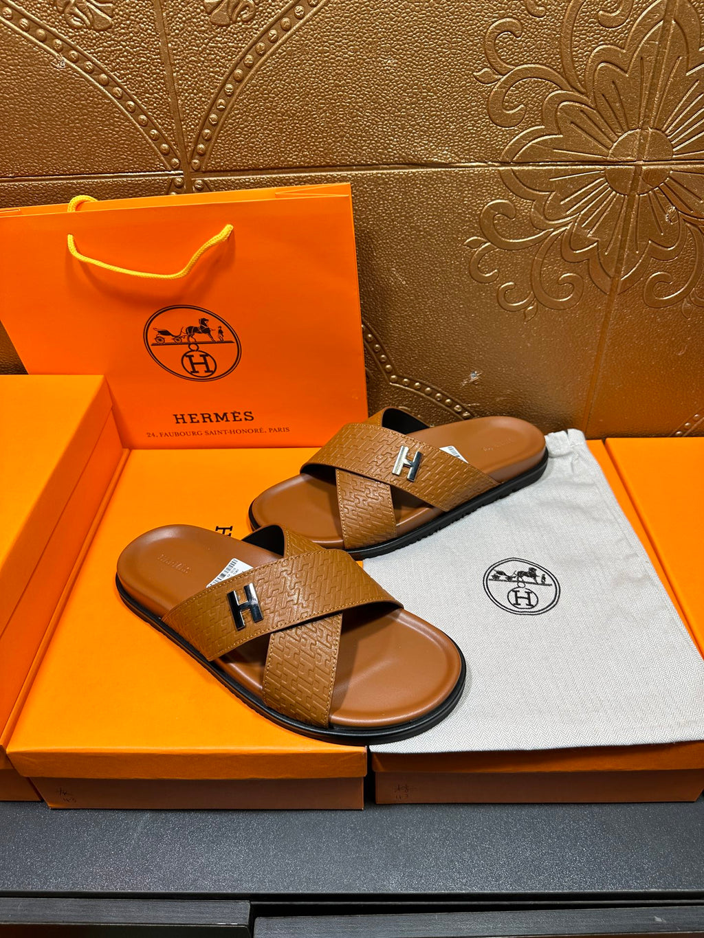 Hermes slide sandals with tan textured cross straps and H buckle, two shoes