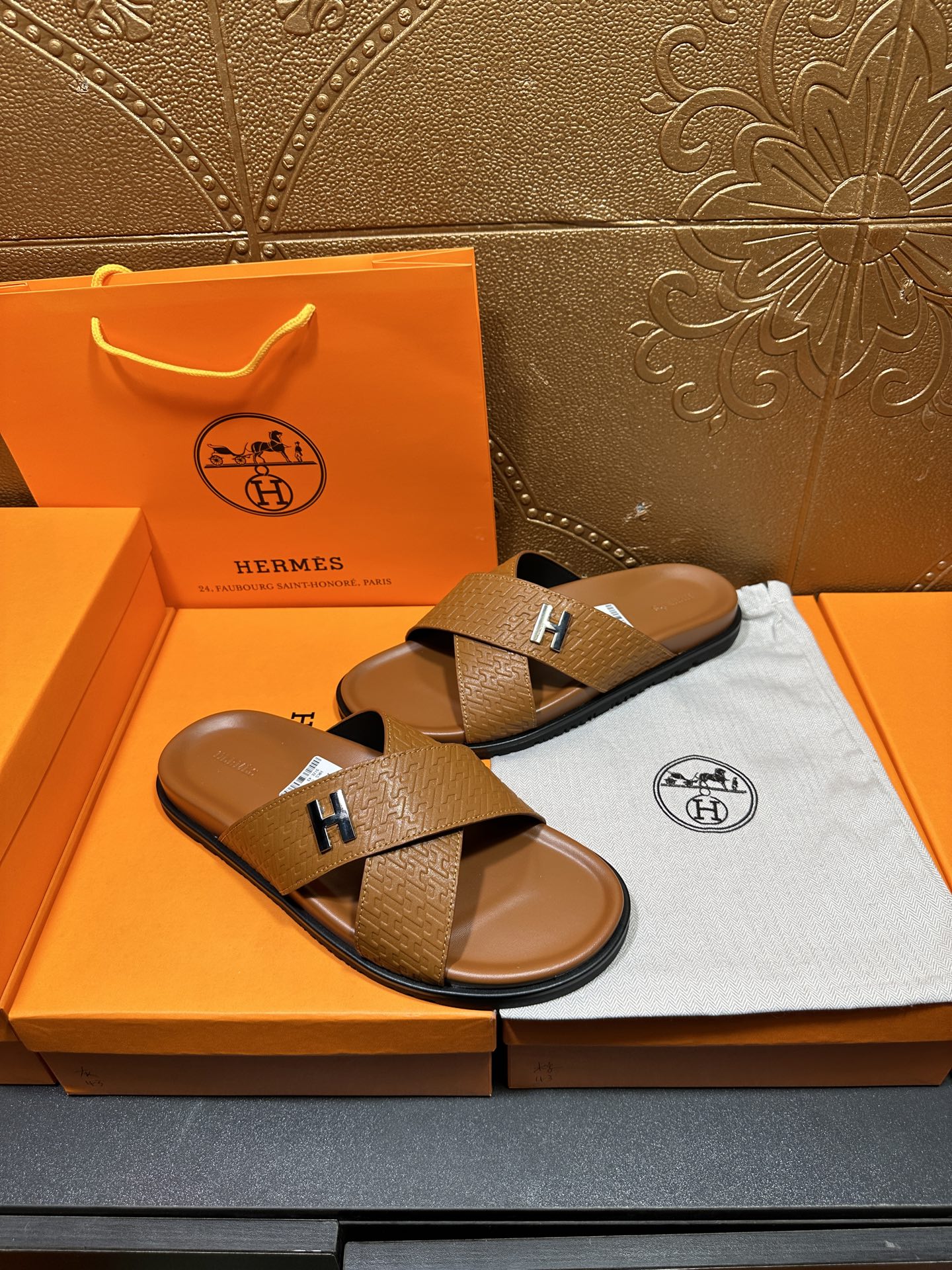 Hermes slide sandals with tan textured cross straps and H buckle, two shoes