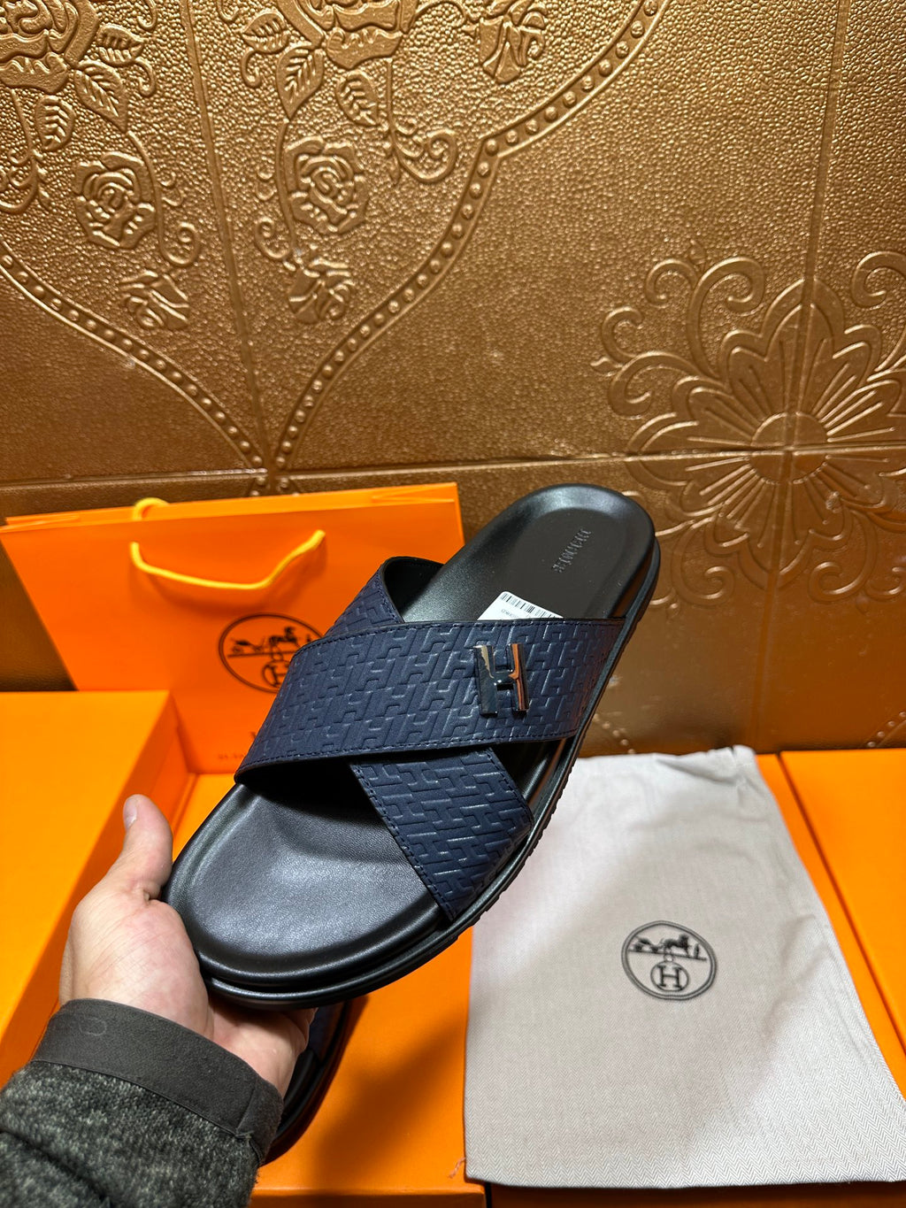 Blue slide sandal with H logo cross strap and black footbed, single pair angle