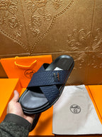 Blue slide sandal with H logo cross strap and black footbed, single pair angle