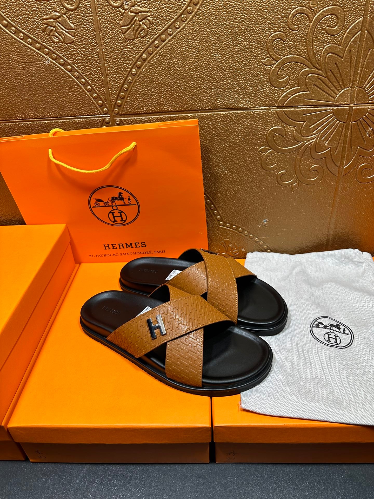 Pair of brown textured leather slide sandals with black footbeds and H logos