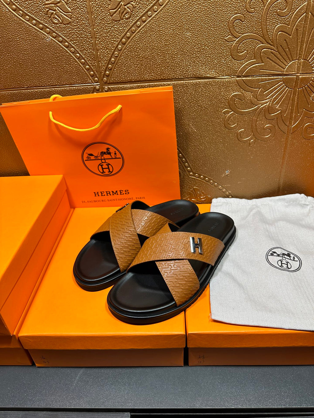 Brown textured leather slide sandals, black straps and footbeds with H logo
