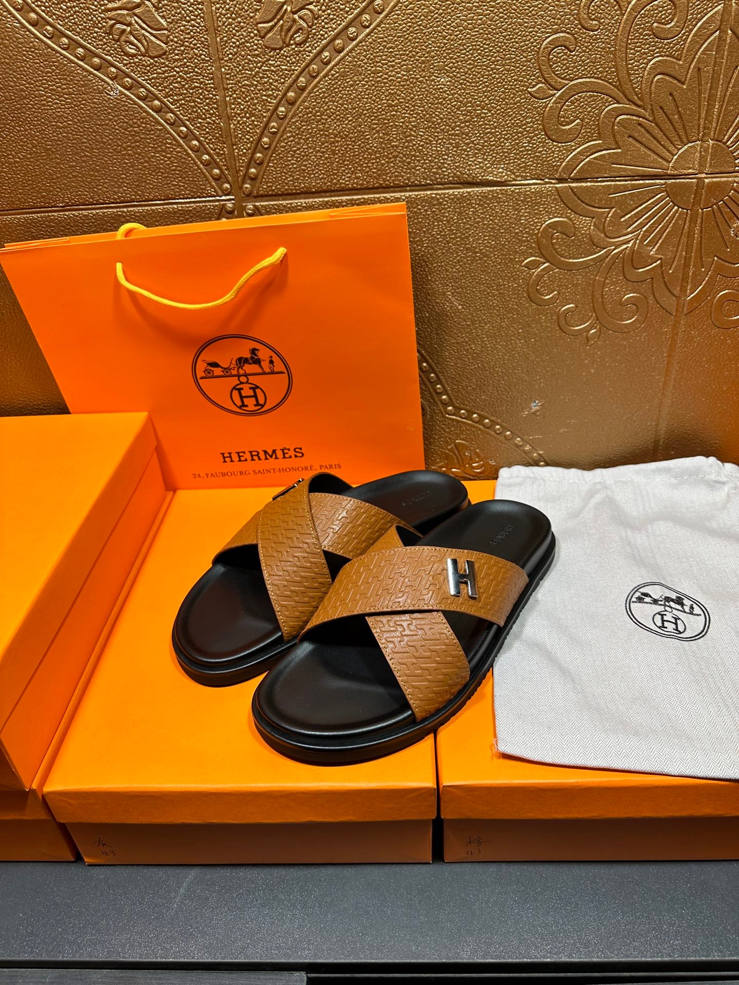 Brown textured leather slide sandals, black straps and footbeds with H logo