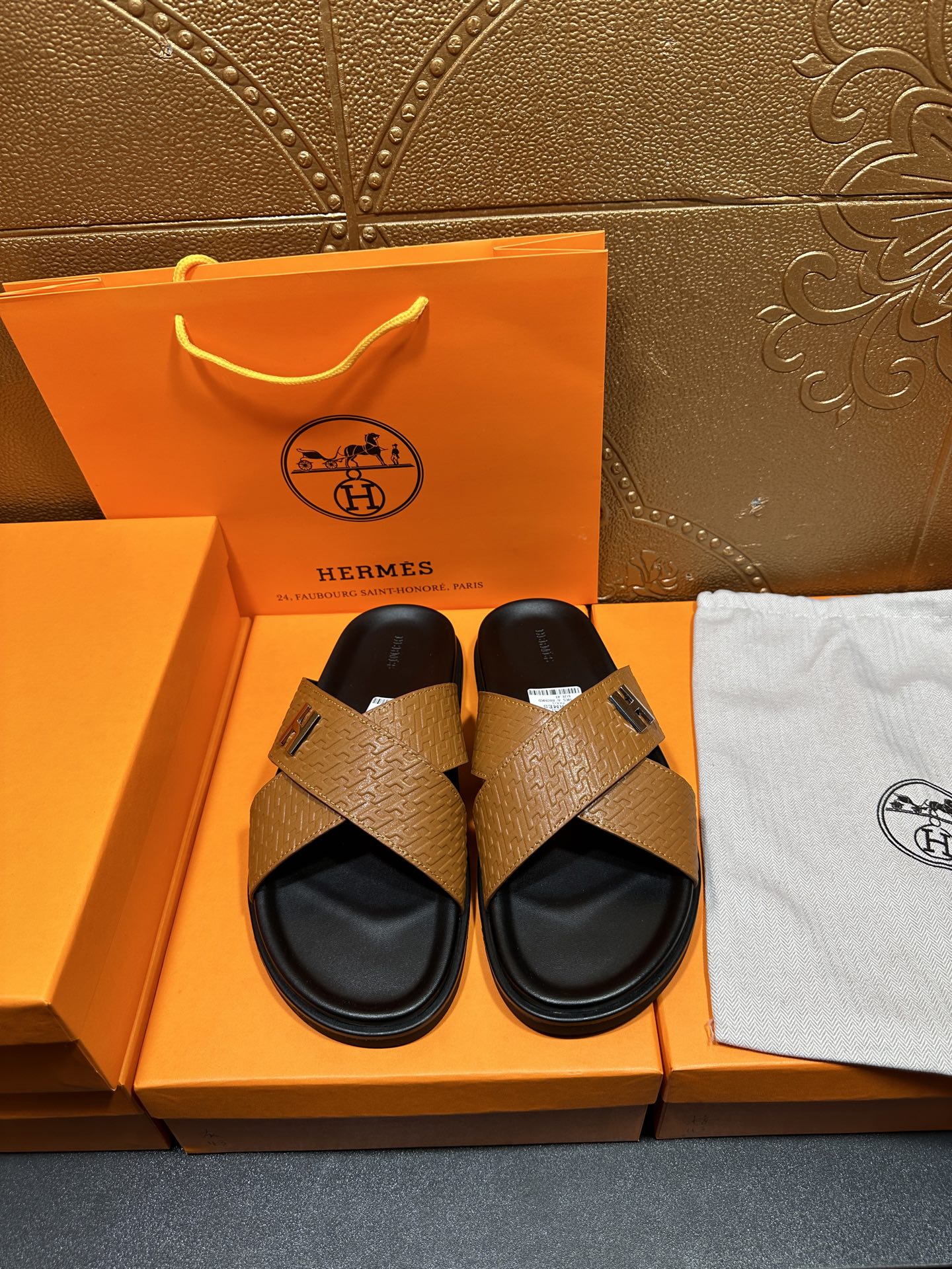 Brown textured leather slide sandals with black footbed and H logo strap