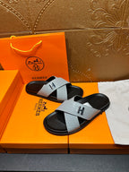 Hermes slide sandals with light gray cross straps, black footbed, H logo buckle