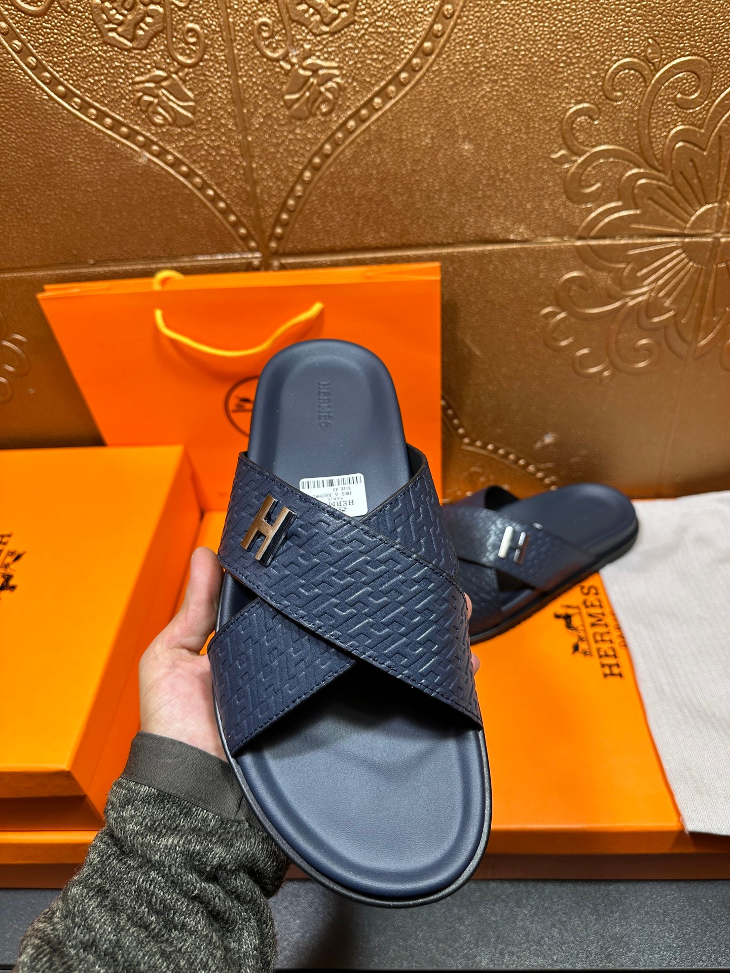 Navy textured slide sandals with H logo buckle, side view