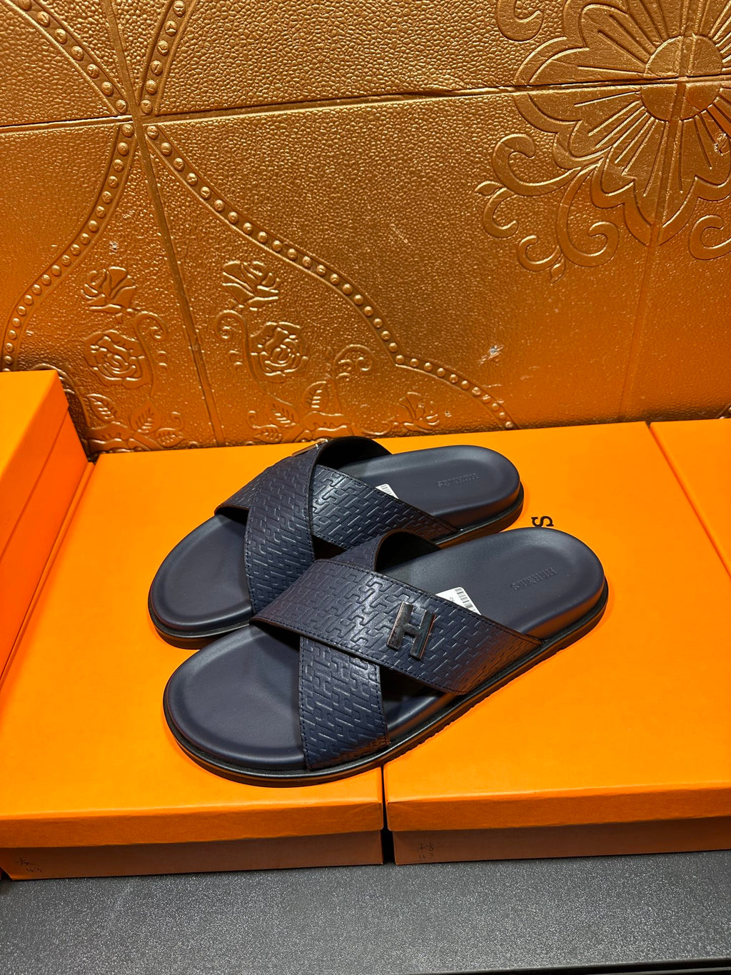 Pair of textured navy slide sandals with black H logo buckle