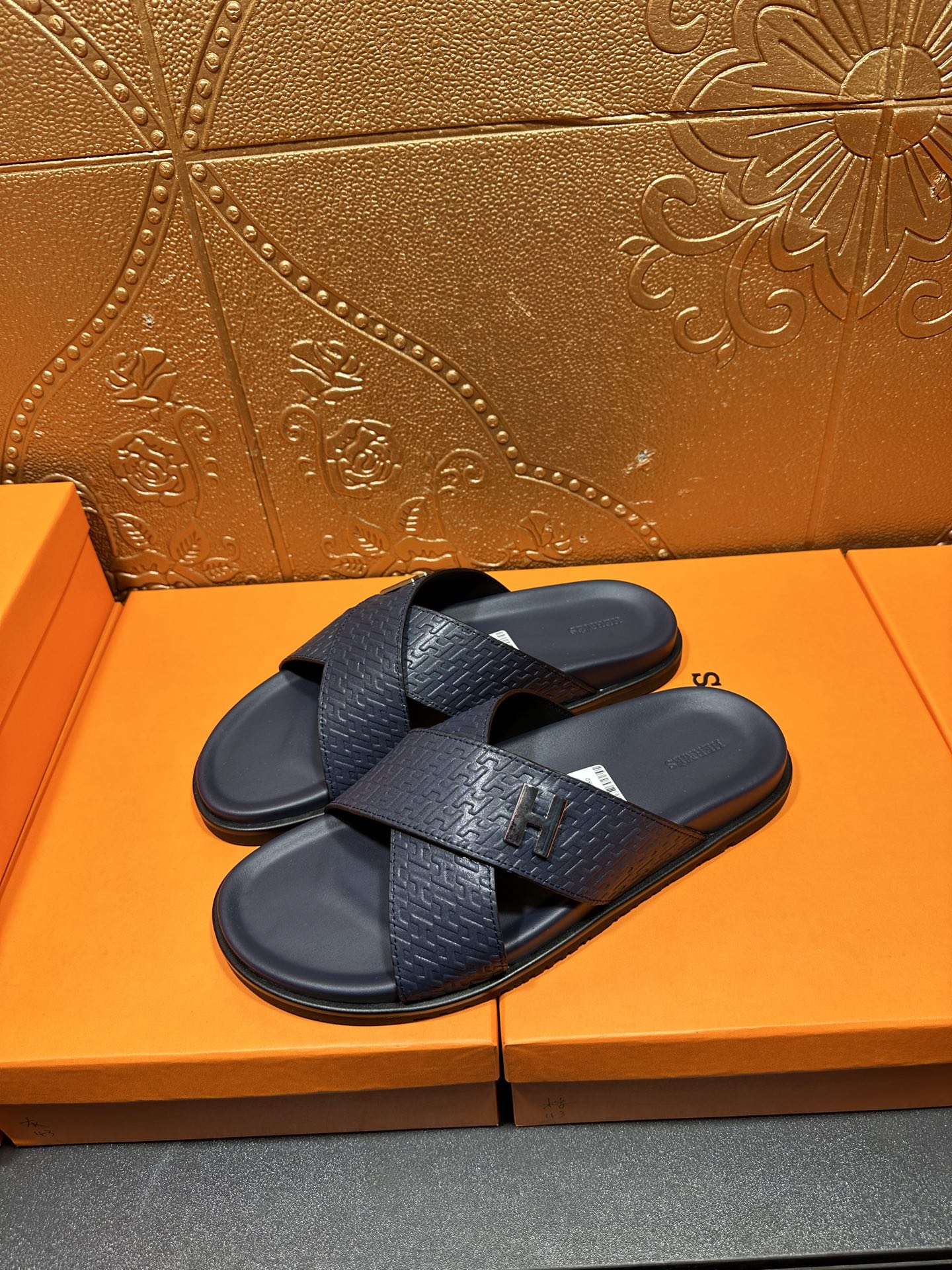 Pair of textured navy slide sandals with black H logo buckle
