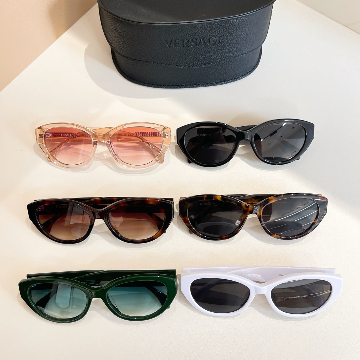 Assorted Versace sunglasses set with peach, black, tortoiseshell, green, and white frames