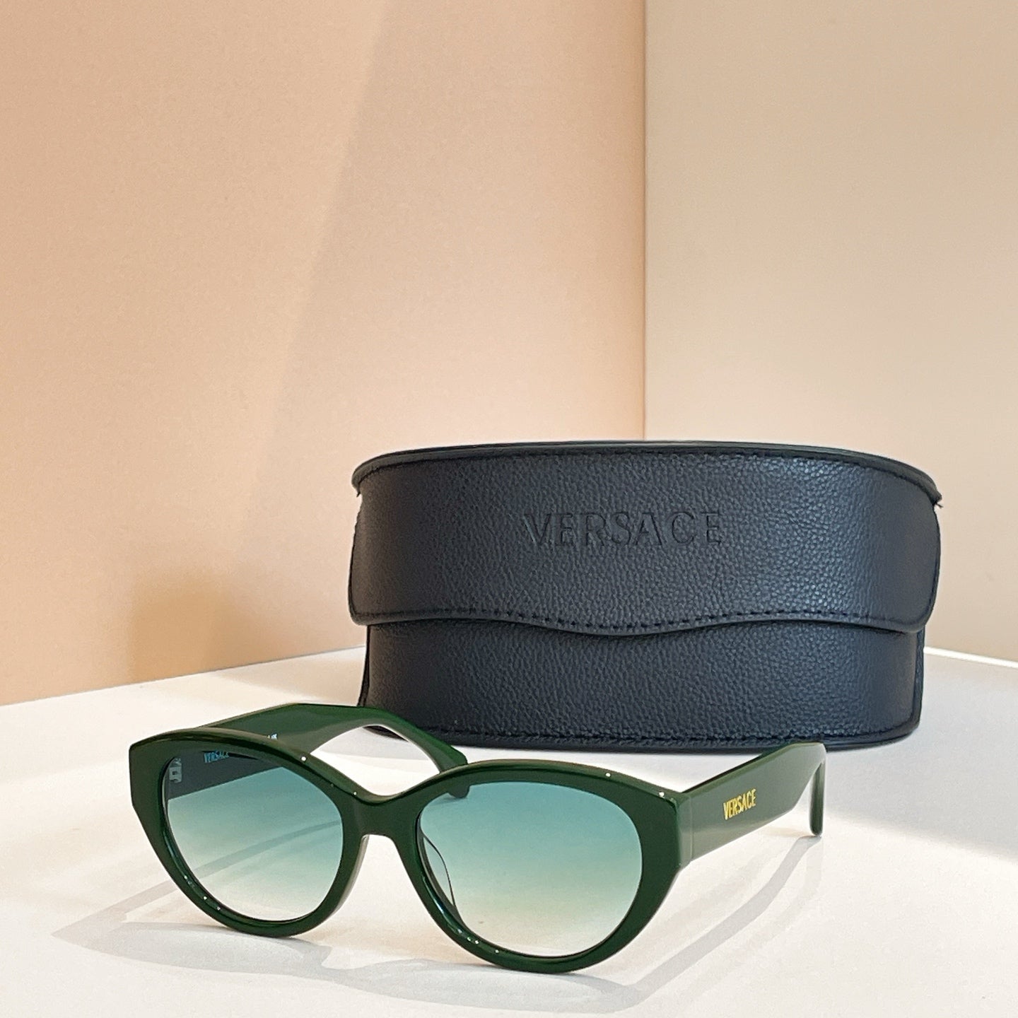 Versace sunglasses with green frames and blue-tinted lenses