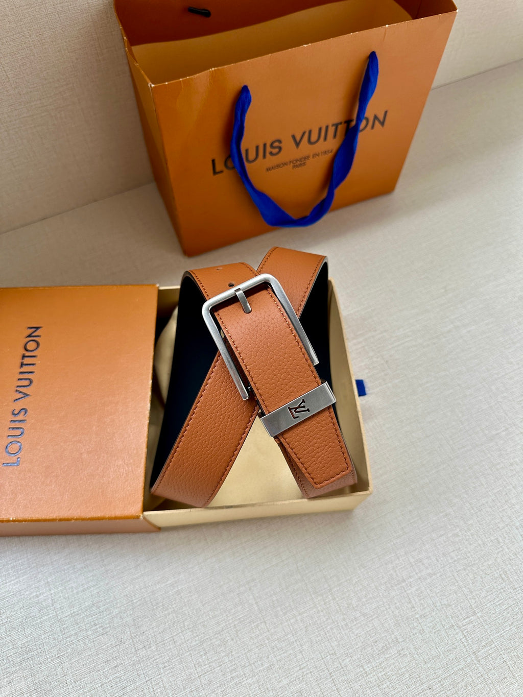 Louis Vuitton leather belt in box, tan strap with silver buckle and LV detail