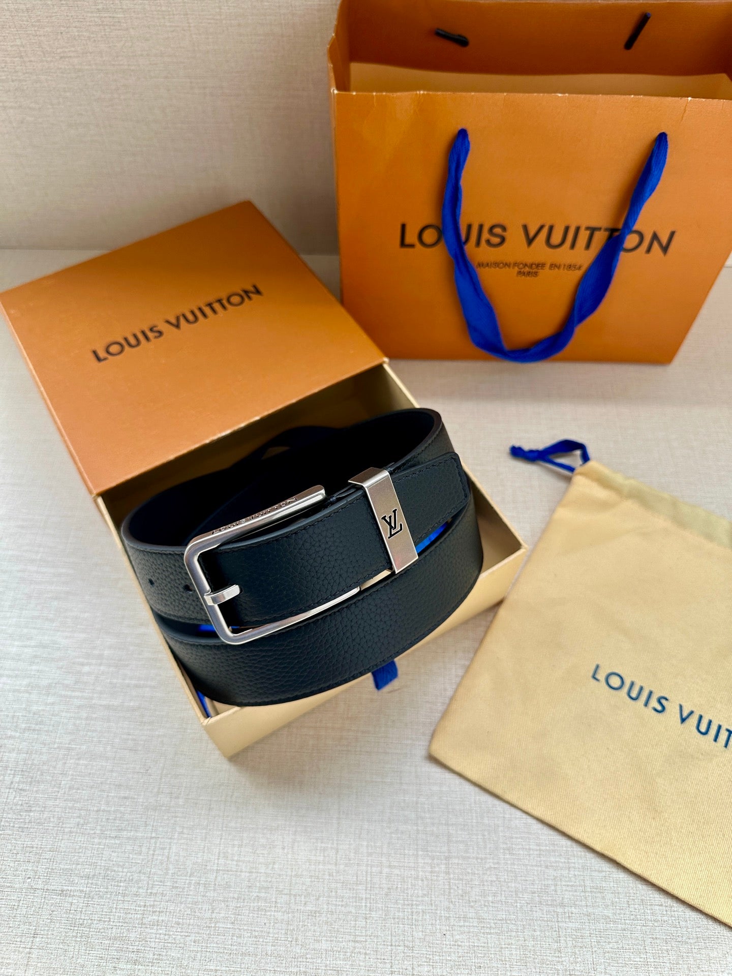 Louis Vuitton belt in dark blue leather with silver-toned buckle in box.
