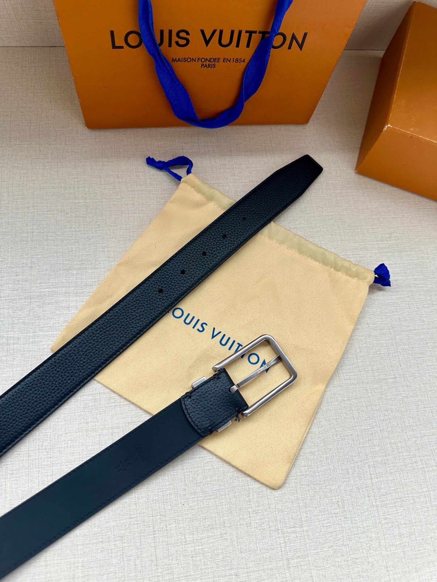 Louis Vuitton belt with dark blue leather strap and silver buckle with keeper loop.