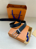 Louis Vuitton belt with dark blue strap and silver-toned buckle in orange box.
