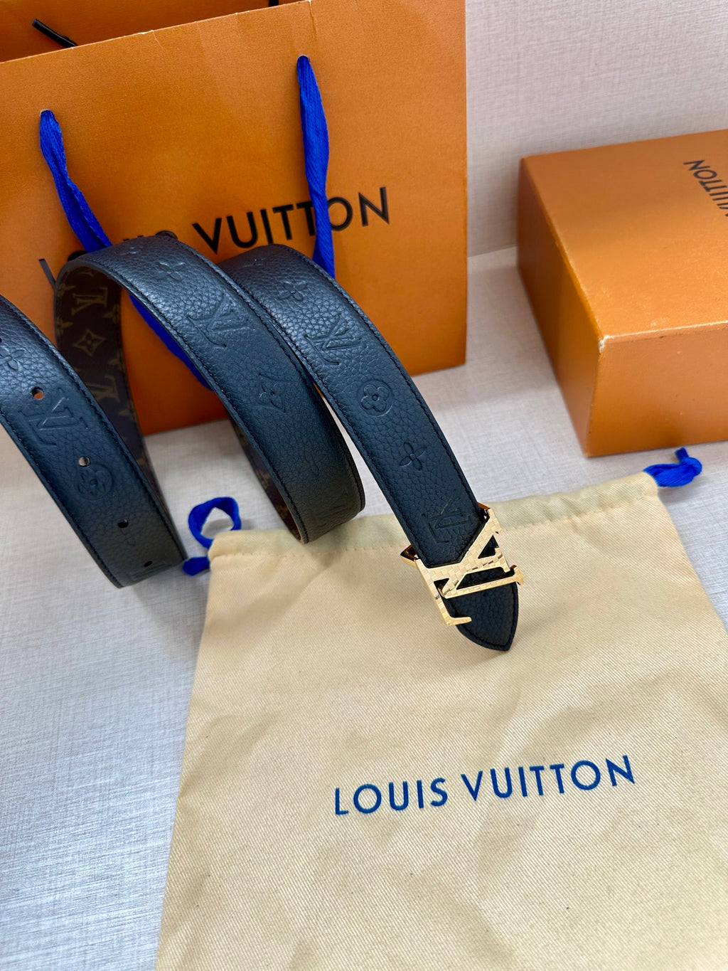 Dark blue leather belt with LV buckle; multiple straps shown