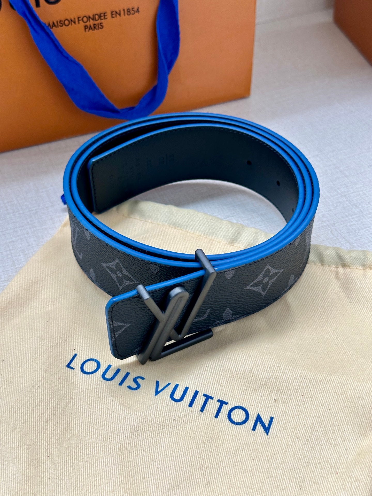 Louis Vuitton belt, dark monogram strap with blue edge lining and metal buckle