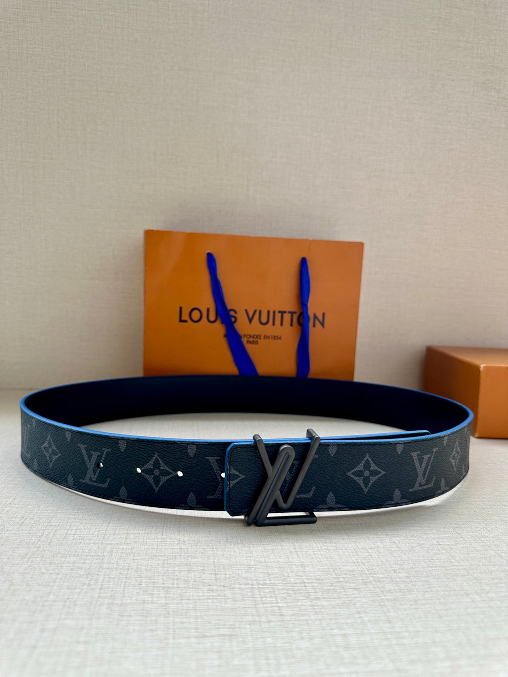 Louis Vuitton belt, dark monogram canvas with blue edging and V-shaped metal buckle