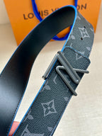 Louis Vuitton belt close-up: dark monogram strap with blue stitching and silver buckle
