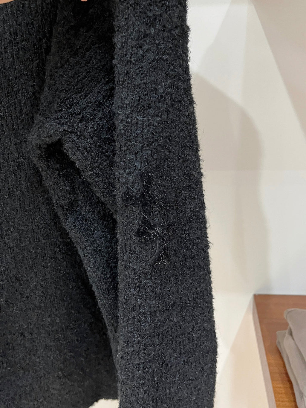 Dark textured sweater sleeve with knit texture and ribbed cuff