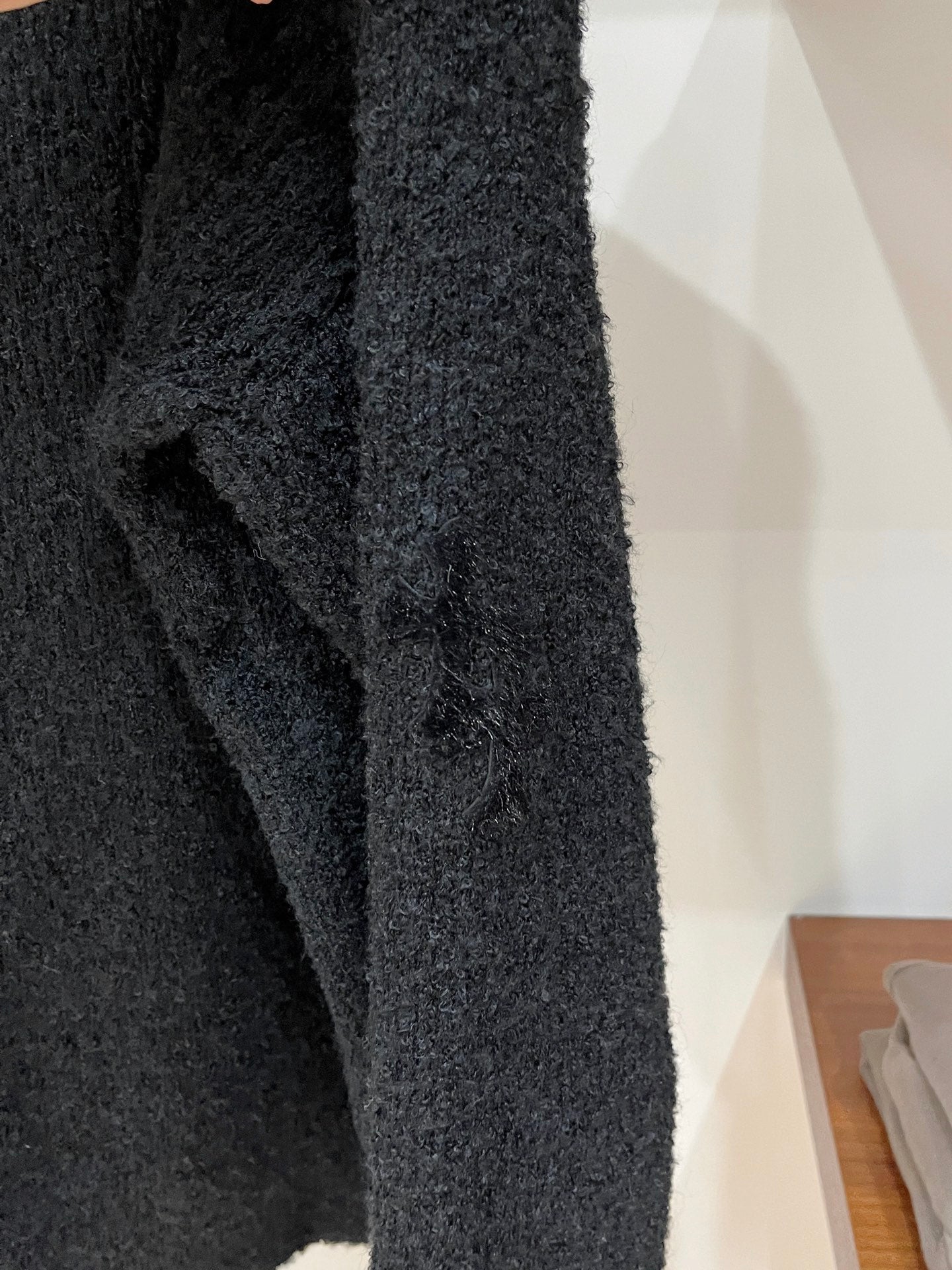 Dark textured sweater sleeve with knit texture and ribbed cuff