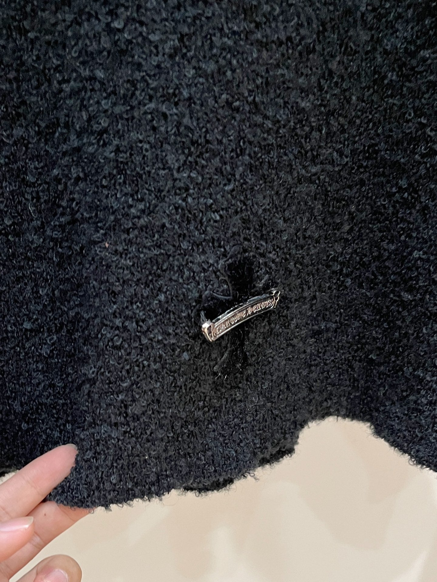 Dark textured sweater with small chest logo pin detail