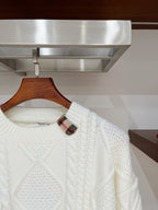 Cream cable-knit sweater close-up at neckline with plaid inner collar
