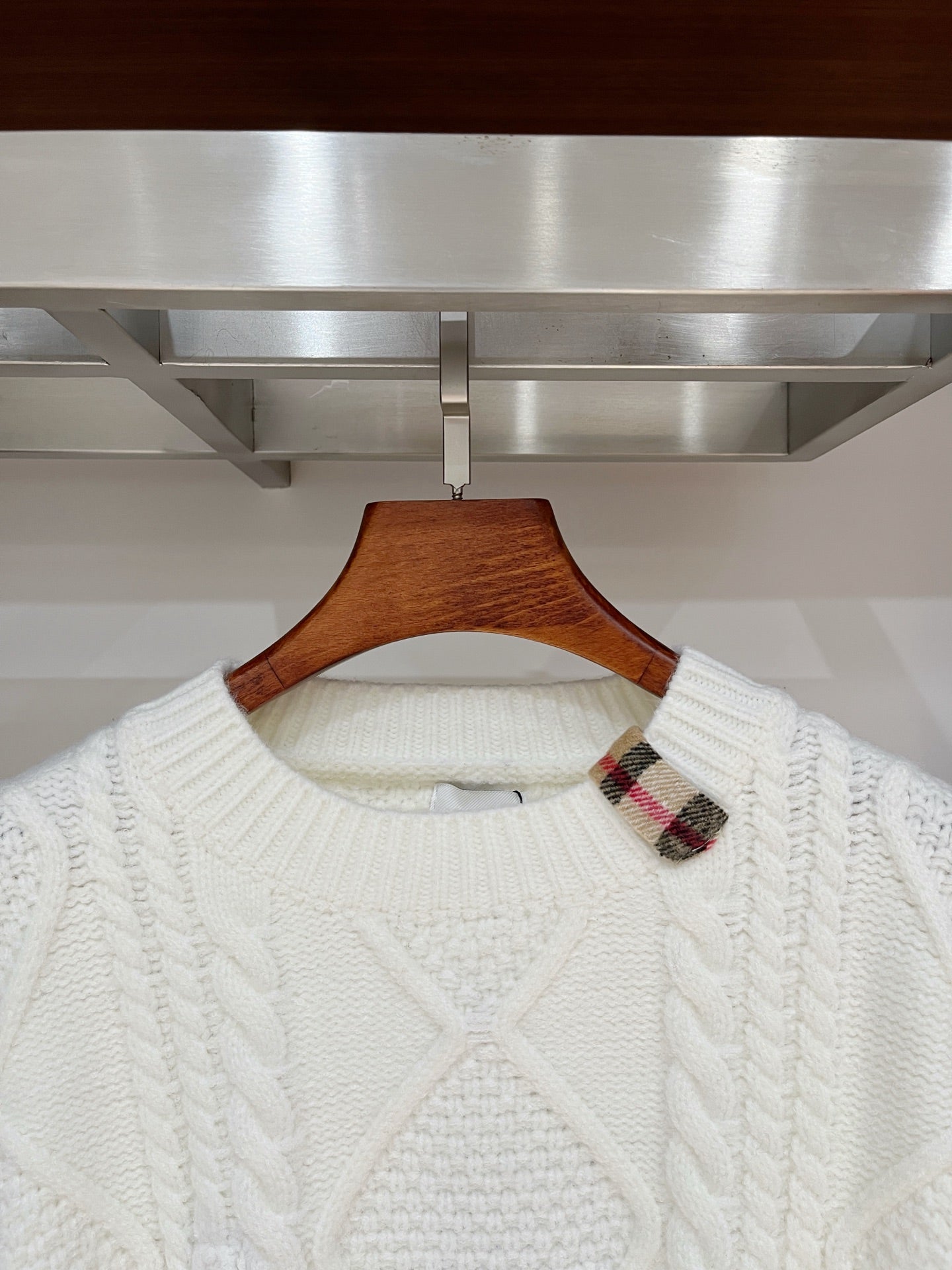 Cream cable-knit crewneck sweater with plaid inner collar detail