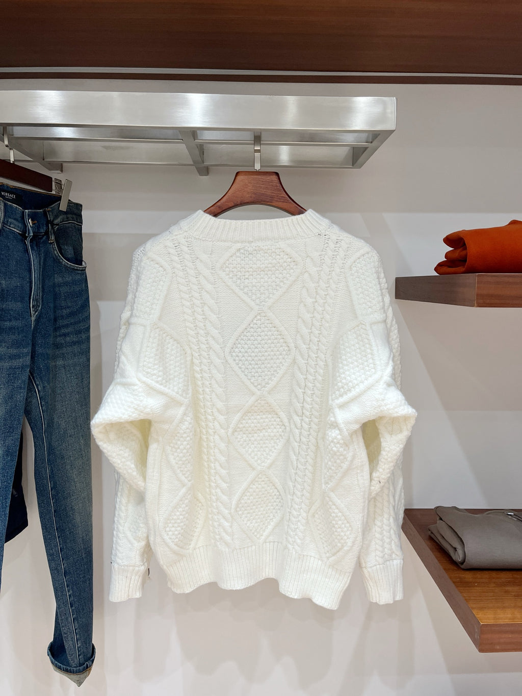 Cream cable-knit long-sleeve sweater with crewneck and fitted ribbed cuffs
