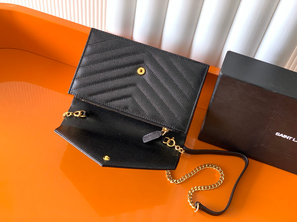 YSL black quilted flap bag with gold chain strap and front button snap
