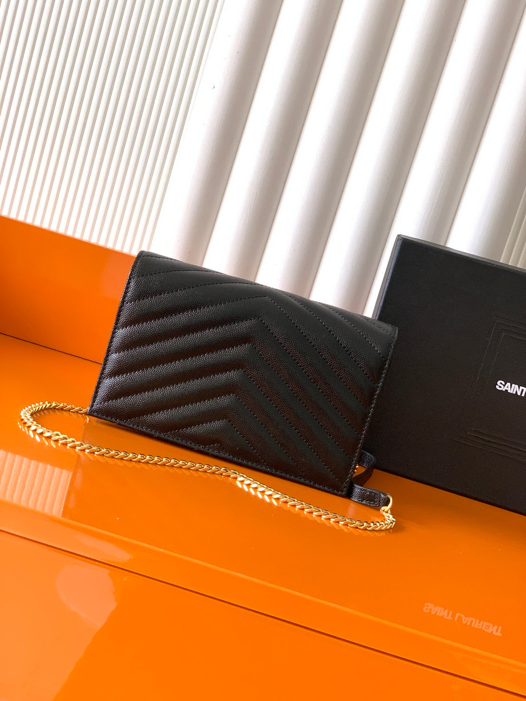 YSL black quilted flap bag with gold chain strap and YSL-style logo at center