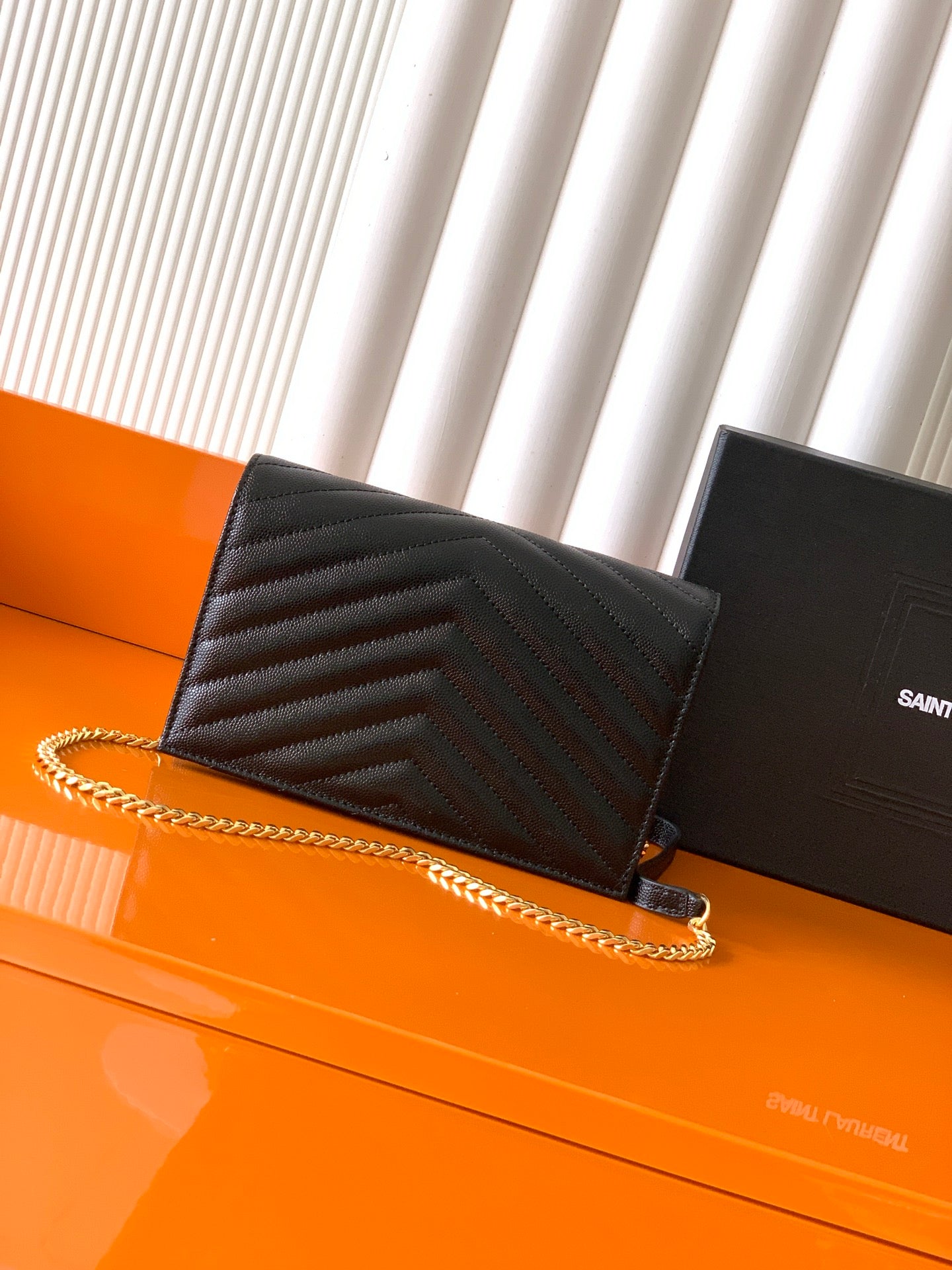 YSL black quilted flap bag with gold chain strap and YSL-style logo at center