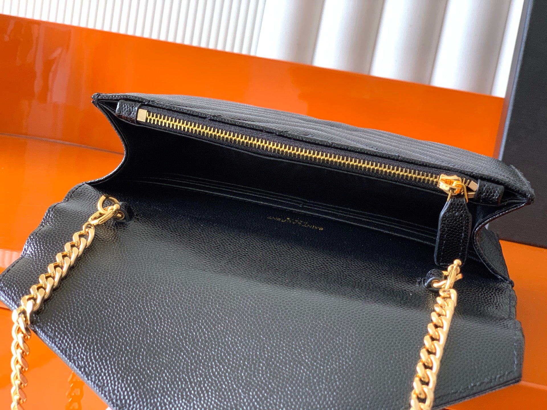YSL black grained leather flap bag open view with gold zipper and chain