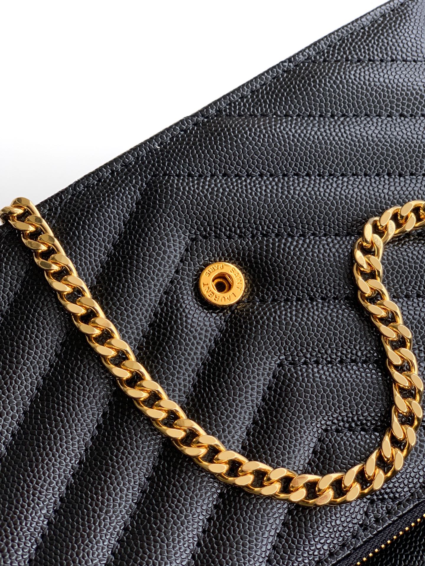 YSL black quilted flap bag close-up with gold hardware and chain strap