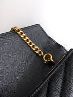 YSL black grained leather flap bag detail with gold chain and snap ring