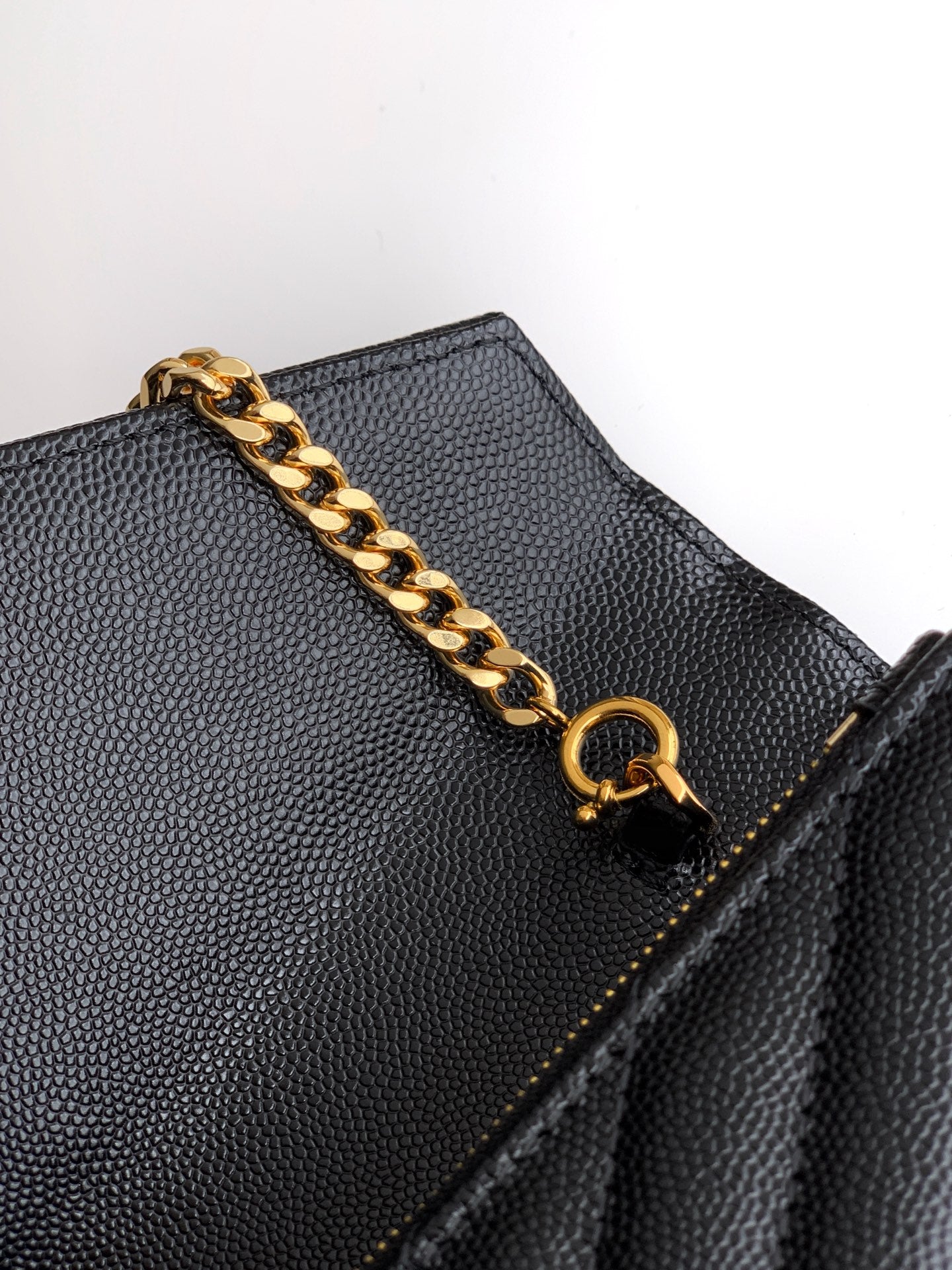 YSL black grained leather flap bag detail with gold chain and snap ring