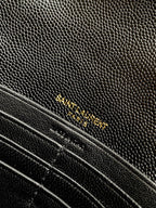 YSL black textured leather bag close-up with gold chain and trim stitching