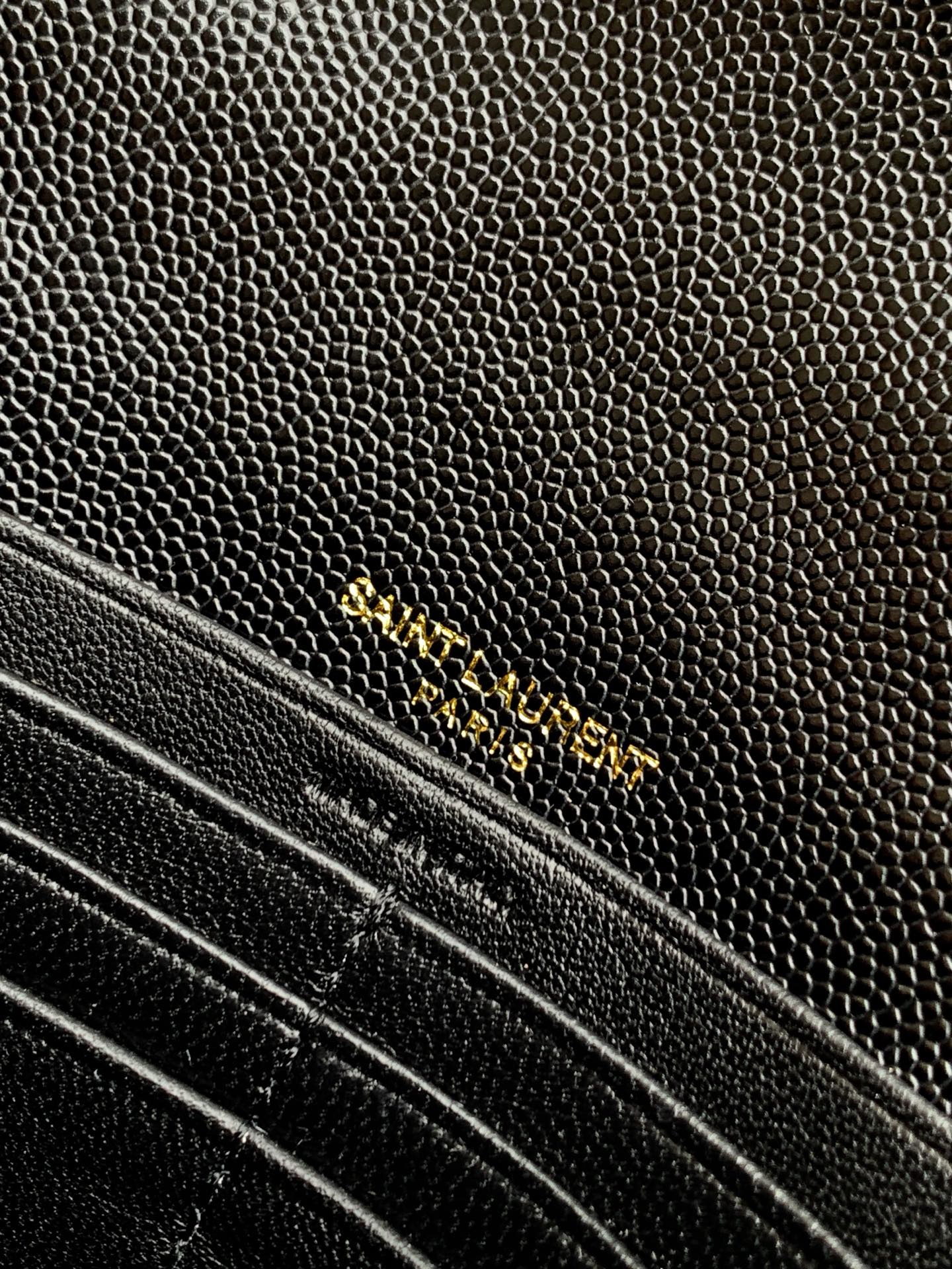YSL black textured leather bag close-up with gold chain and trim stitching