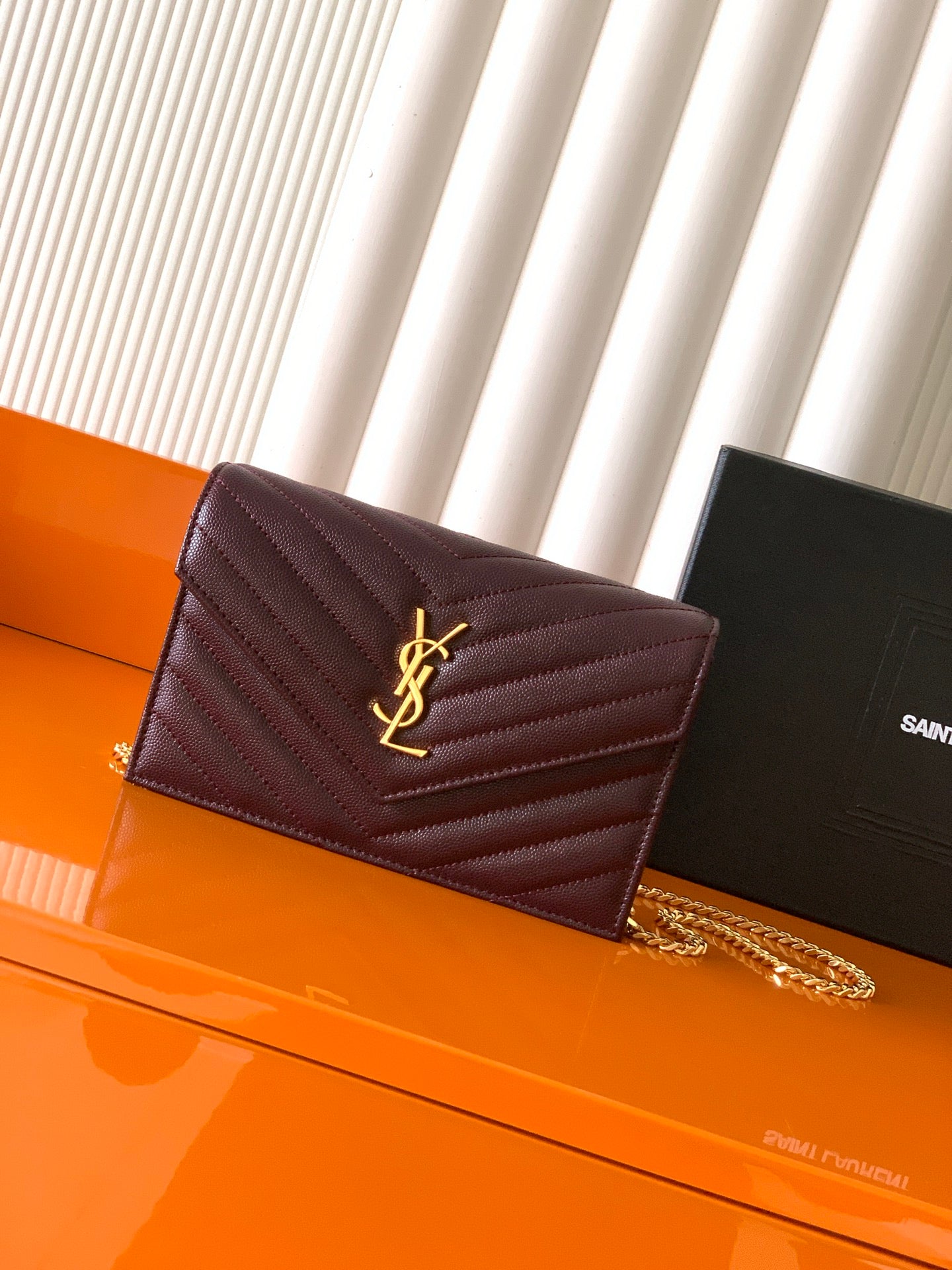 Burgundy quilted YSL flap bag with gold logo and chain shoulder strap