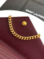 Burgundy flap bag with gold round snap and gold chain shoulder strap