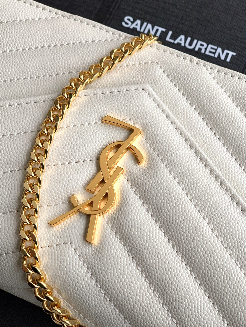 YSL gold logo on white quilted leather flap with chain strap