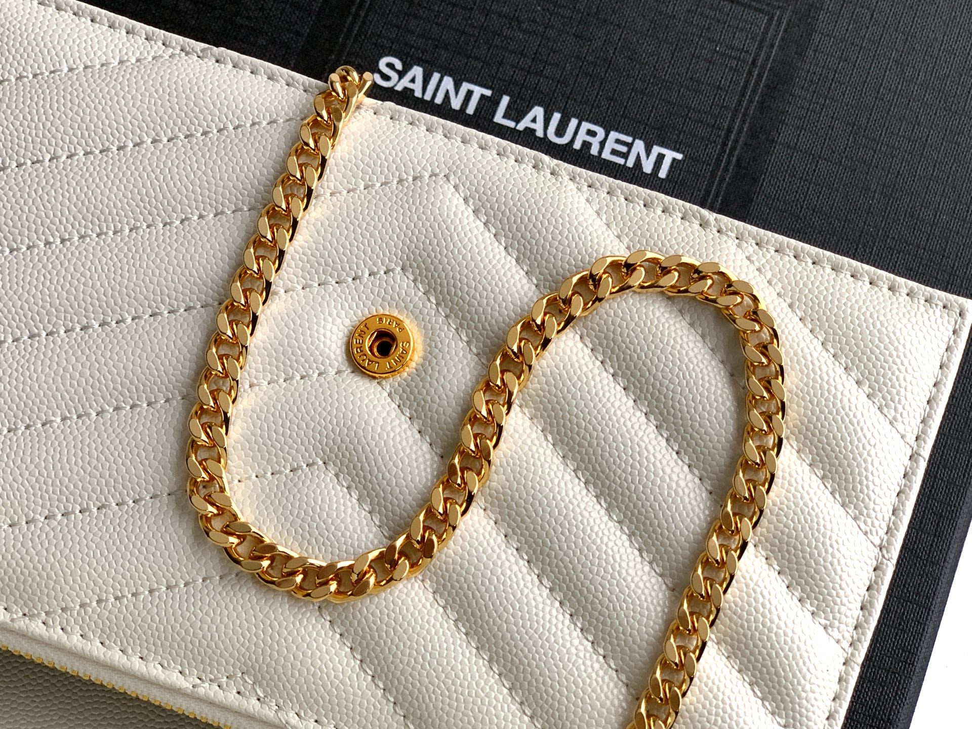 YSL white quilted flap with gold chain and round snap closure