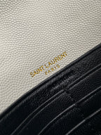 YSL embossed logo on white leather flap with black trim