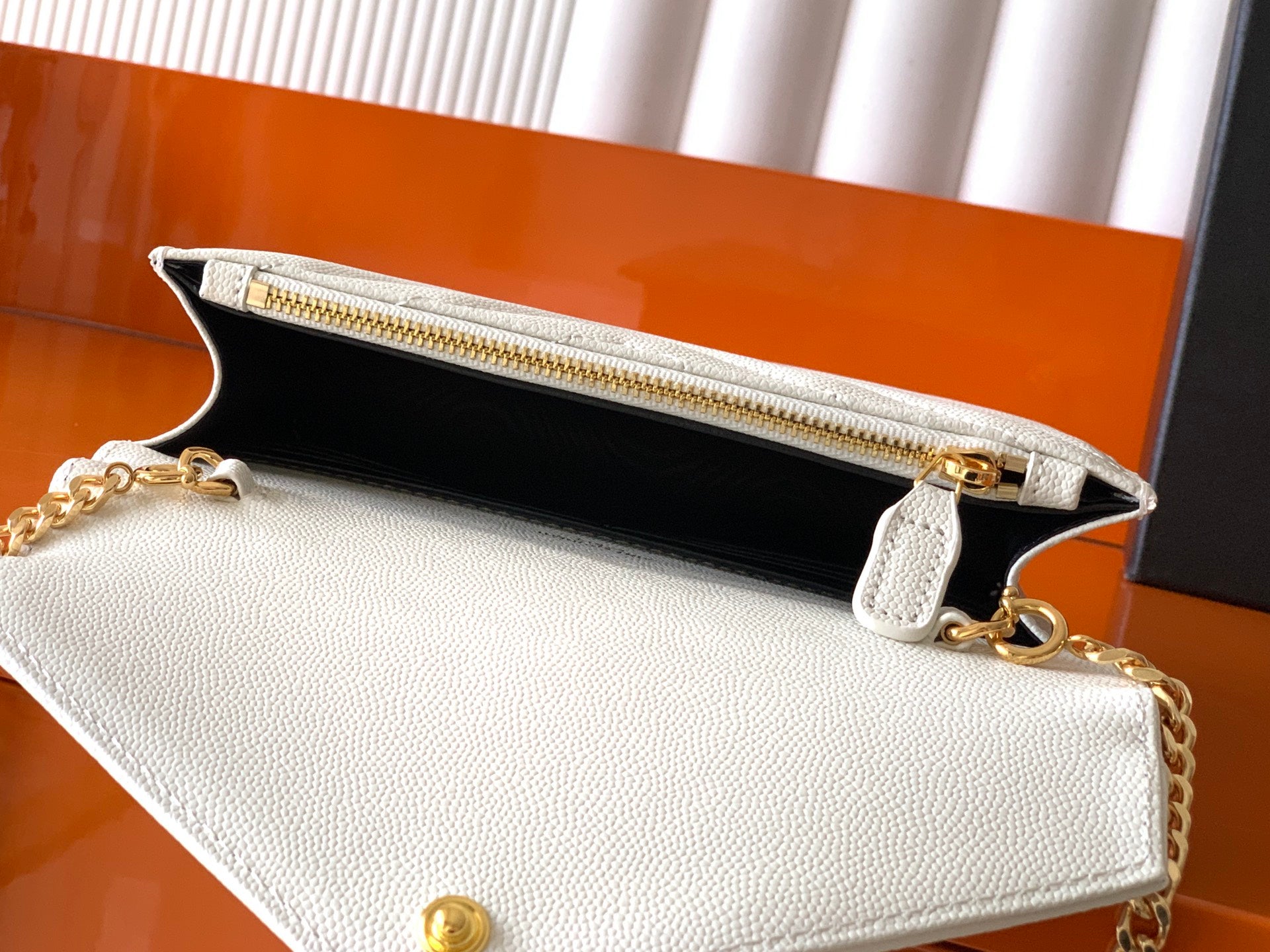 YSL white crossbody bag with black interior lining, zipper and gold hardware